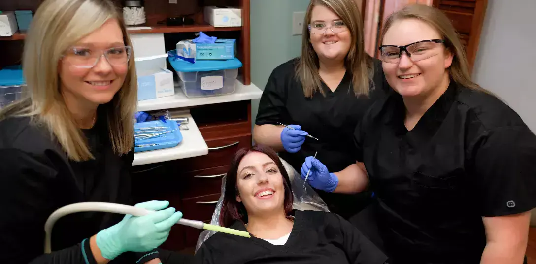 {{ school.name }} students training dental procedures in class